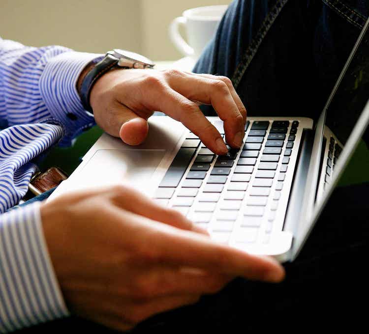 Hands typing on laptop
