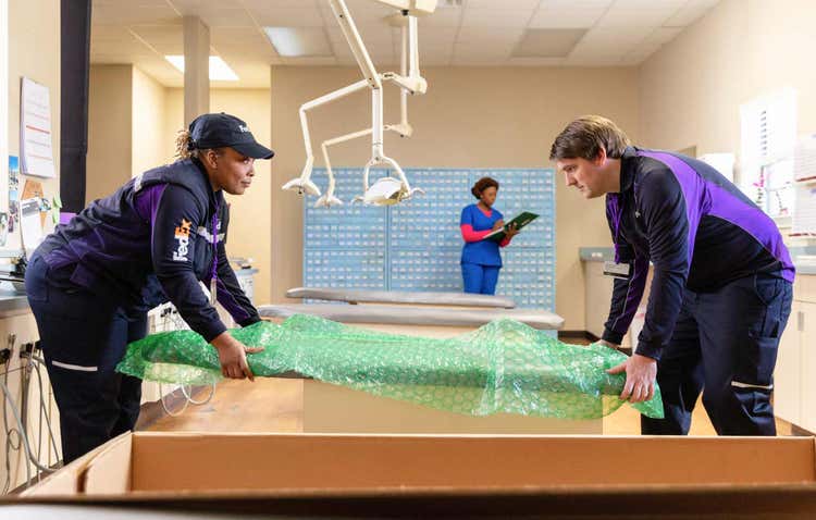 Two FedEx personnel using bubble wrap